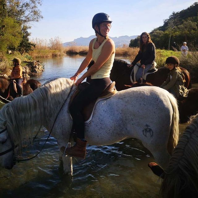 Centro Hípico Oliva Nova personas sobre caballos en un río